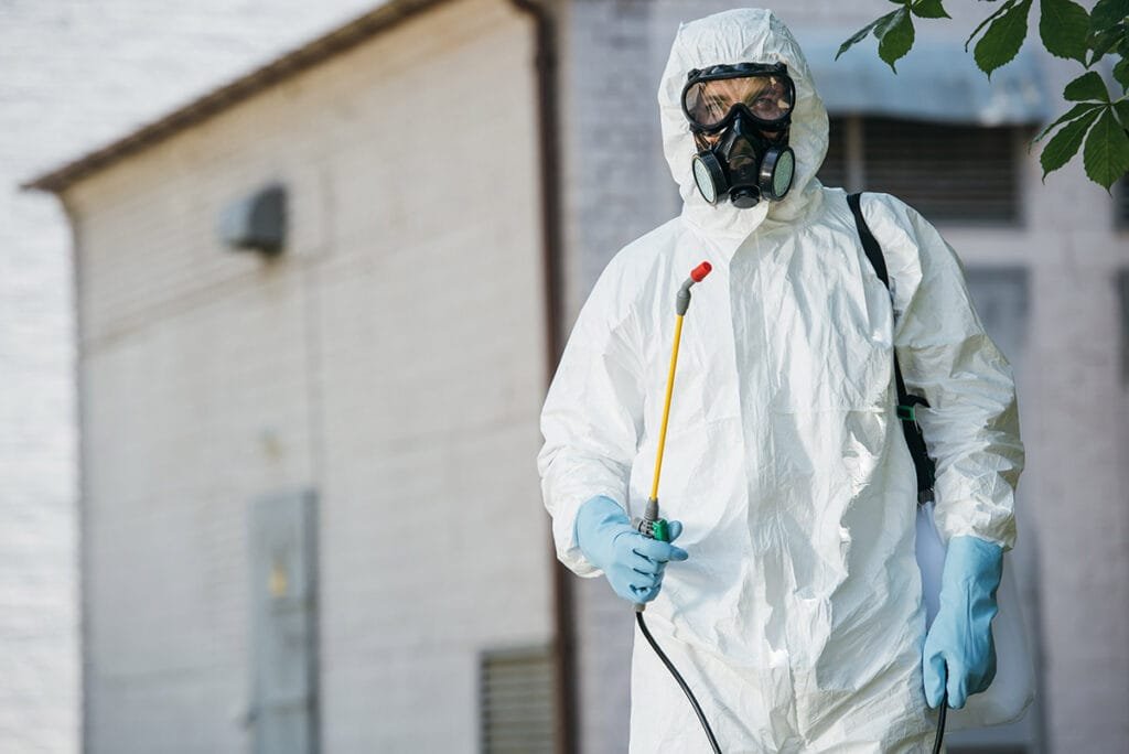 Identifying and Controlling Common Household Pests: A Comprehensive Guide 1 pest control worker in respirator holding sprayer